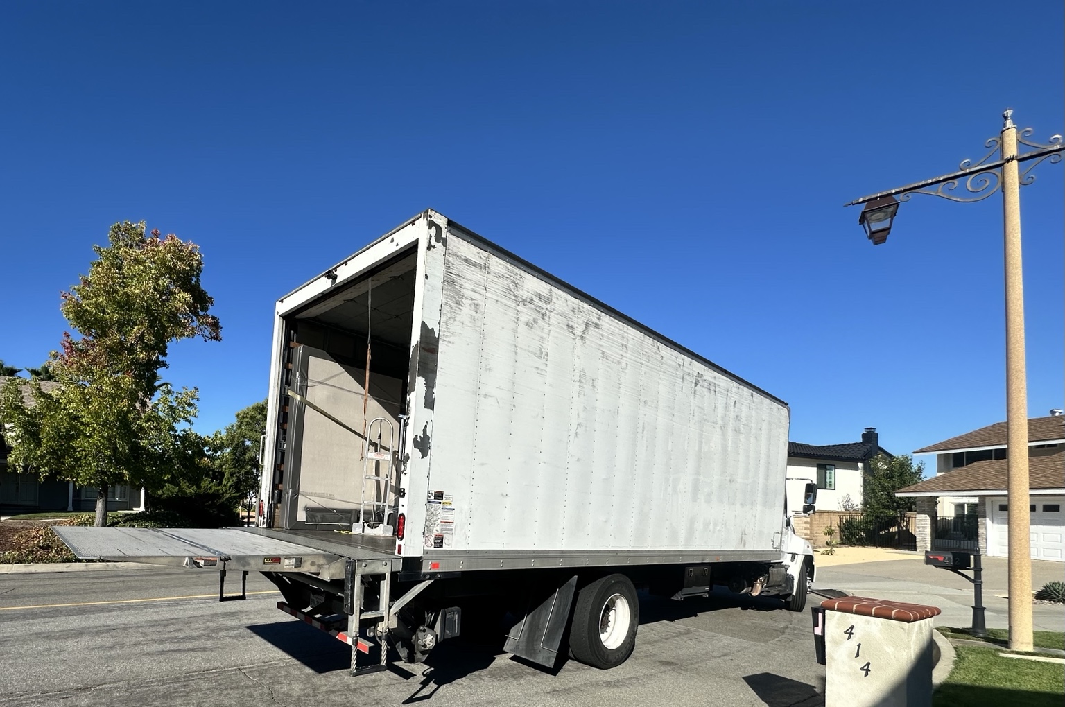 C&D box truck at a residential delivery with its liftgate open