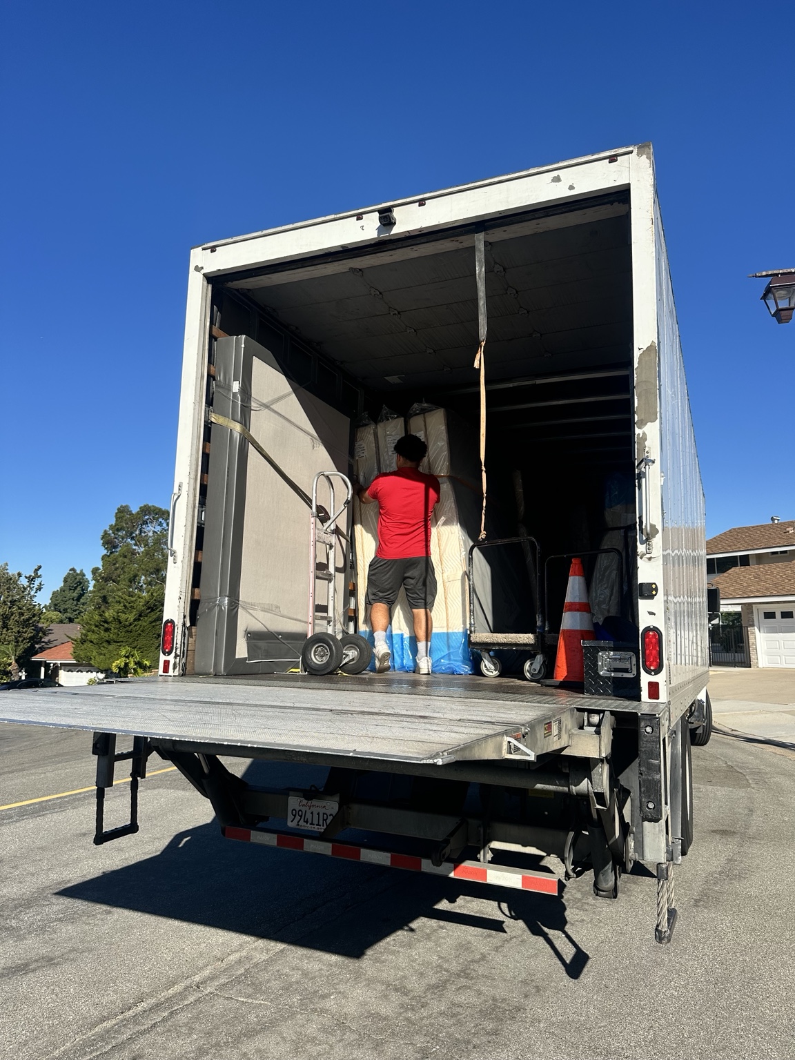 C&D worker handling protected furniture inside the truck with the liftgate open
